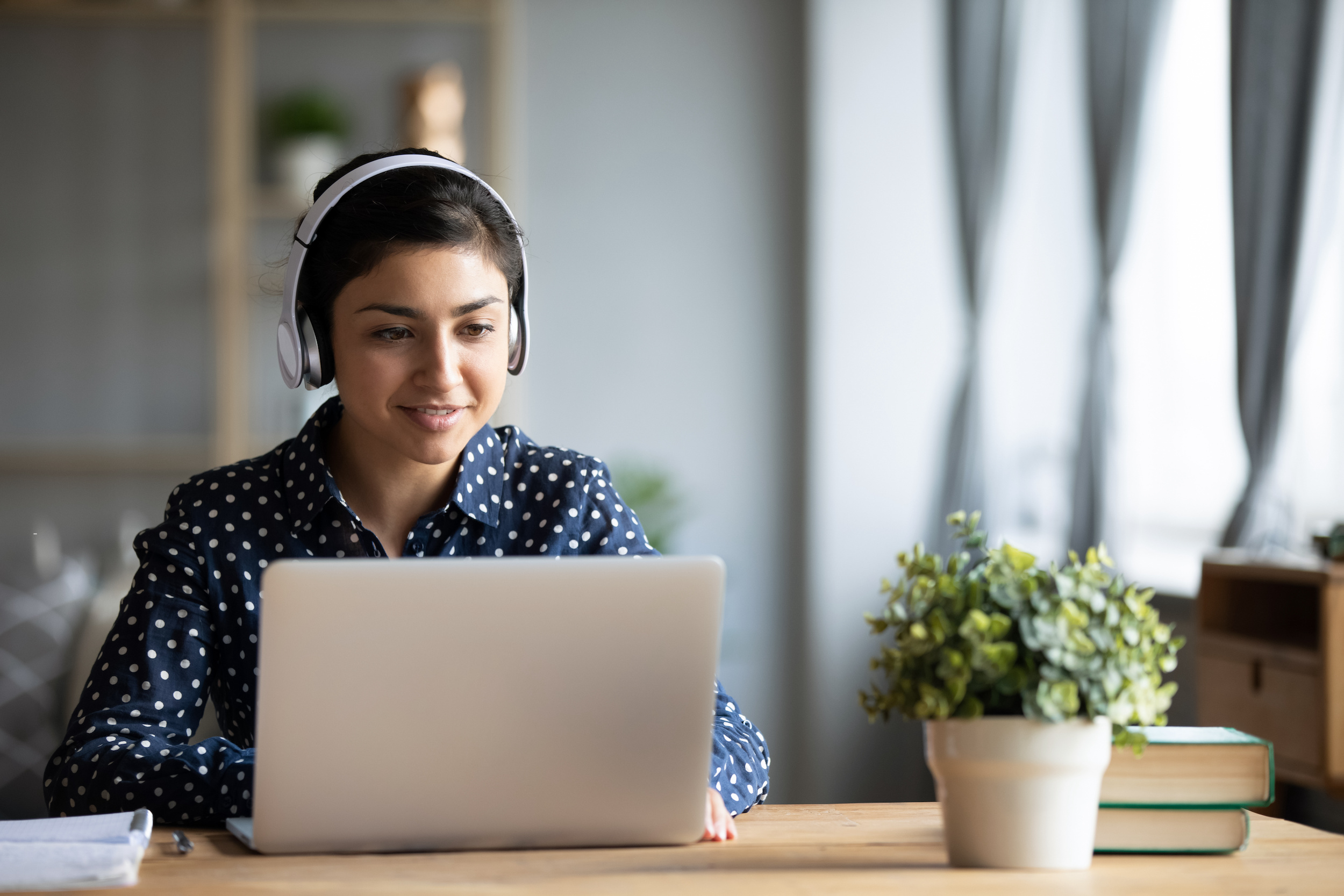 Woman at a laptop with headphones.